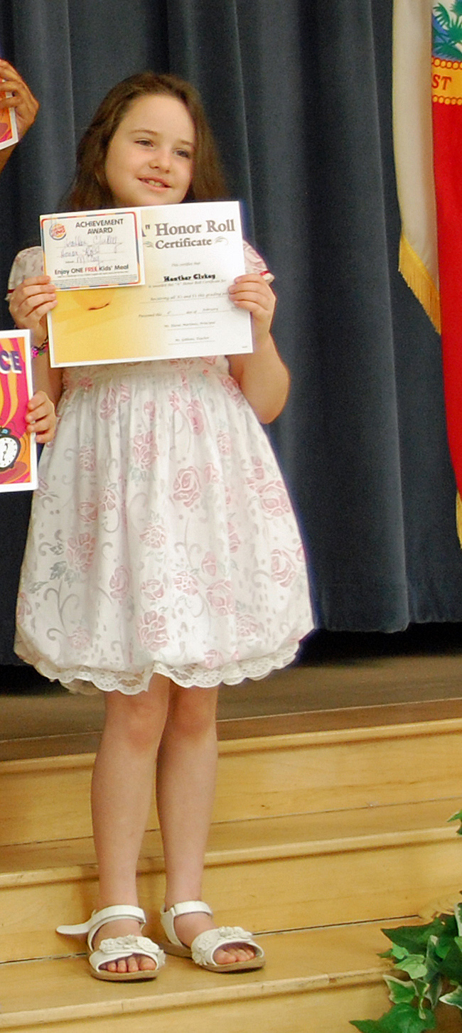 Heather holding up her Honor Roll award certificate.