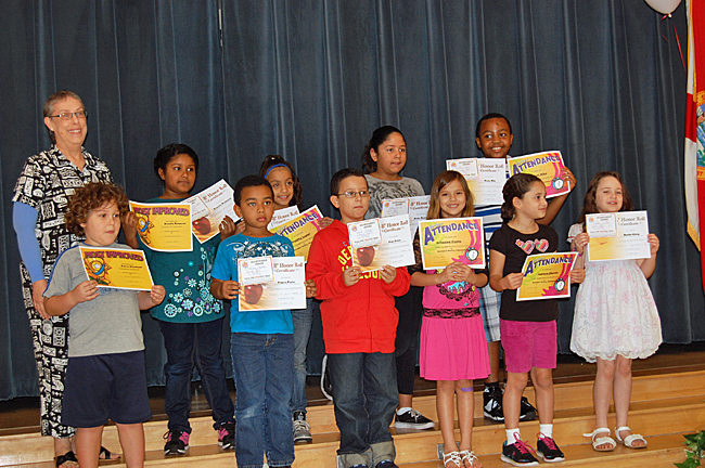 Heather with her teacher and other classmates holding their awards.