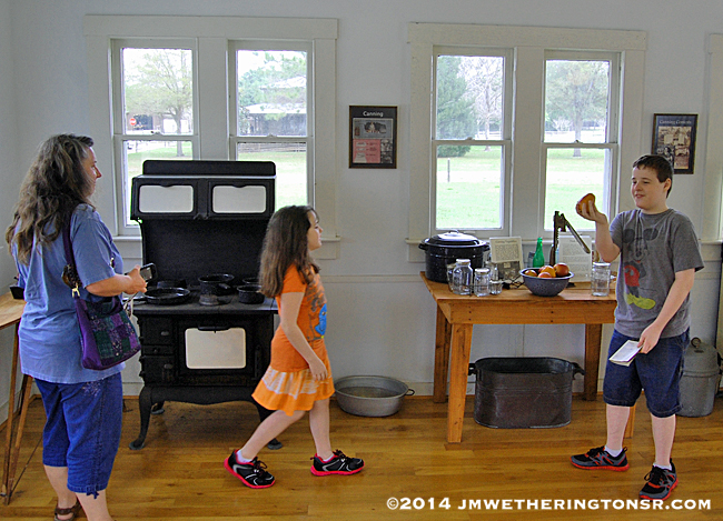 Grandma, Heather and Mikey inside the first lunchroom, exploring the old cooking appliances and utensils.